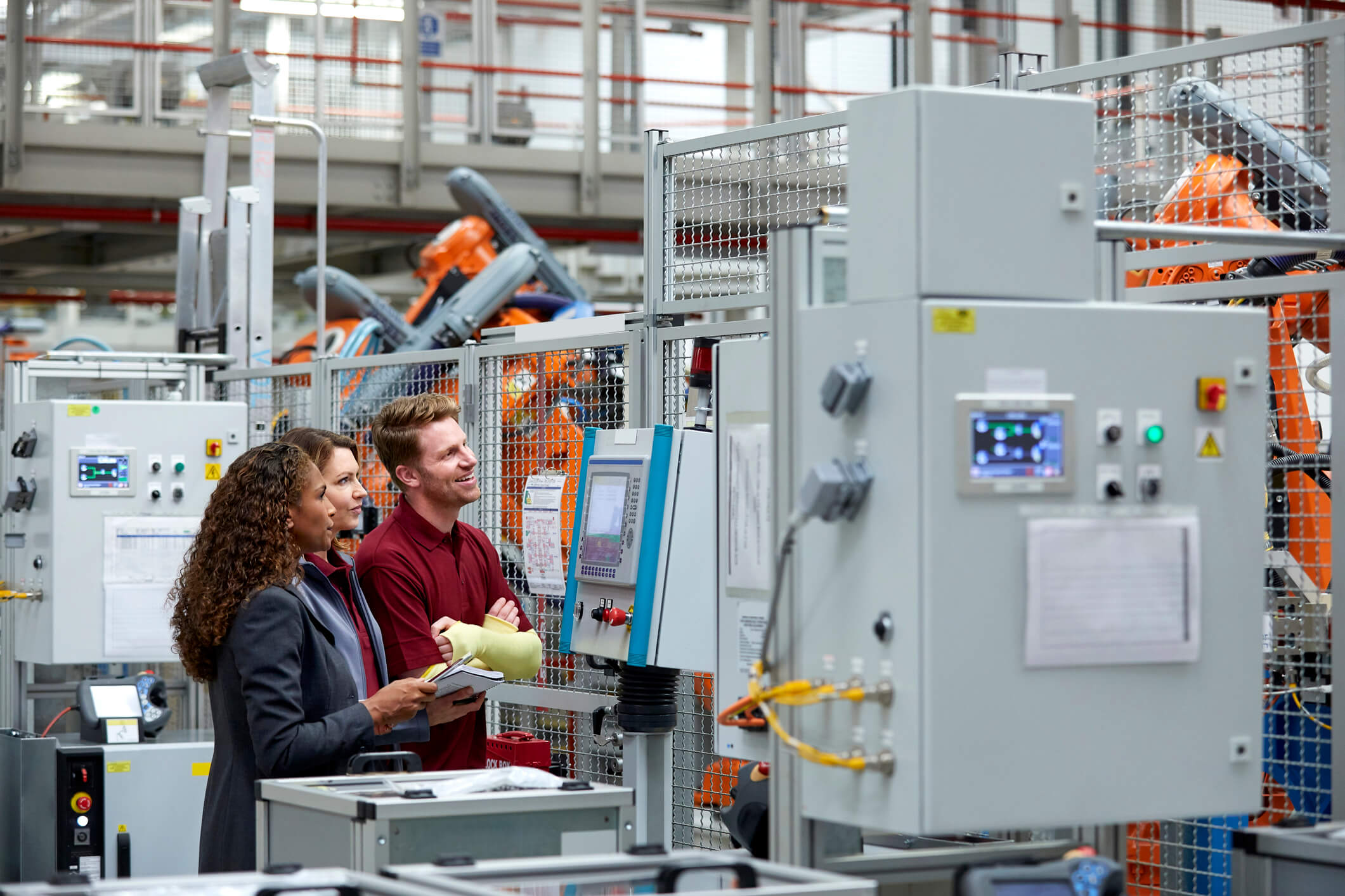Engineers Standing By Control Panel In Auto Plant